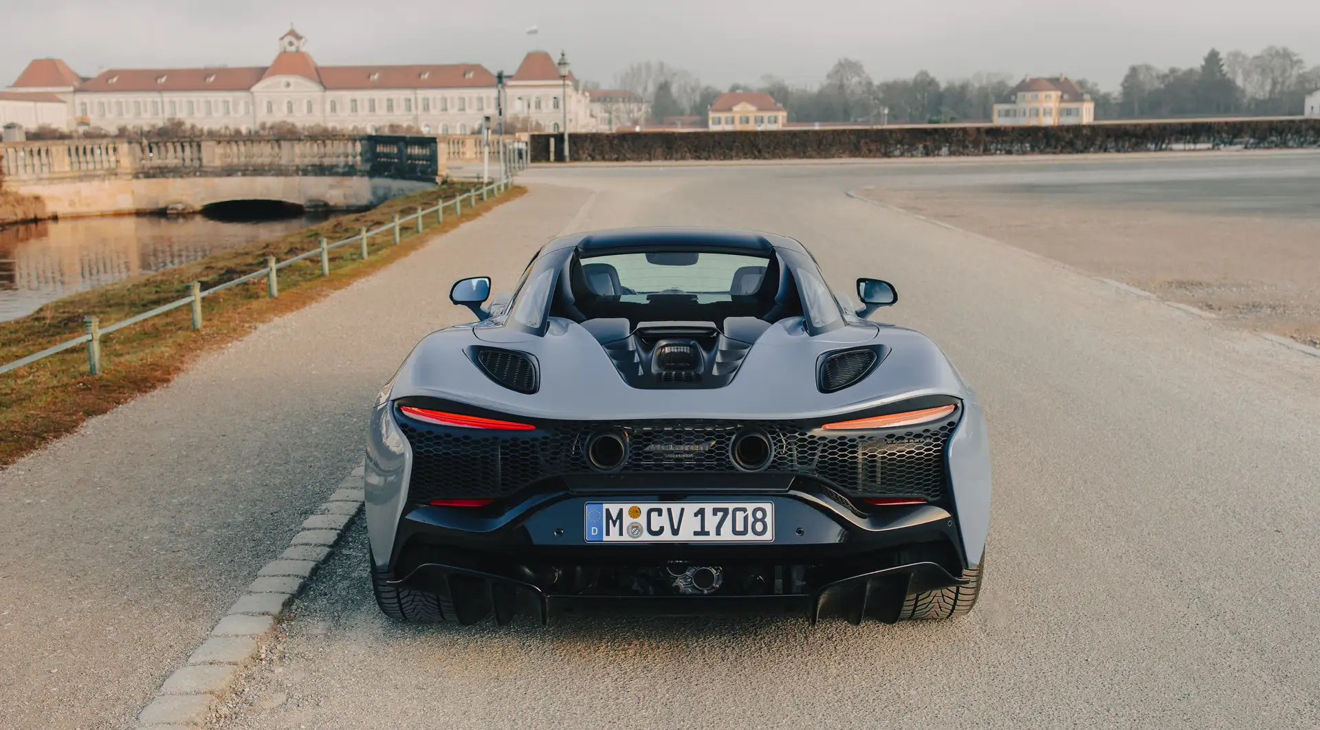 The rear of the McLaren Artura Spider in front of a historic castle building